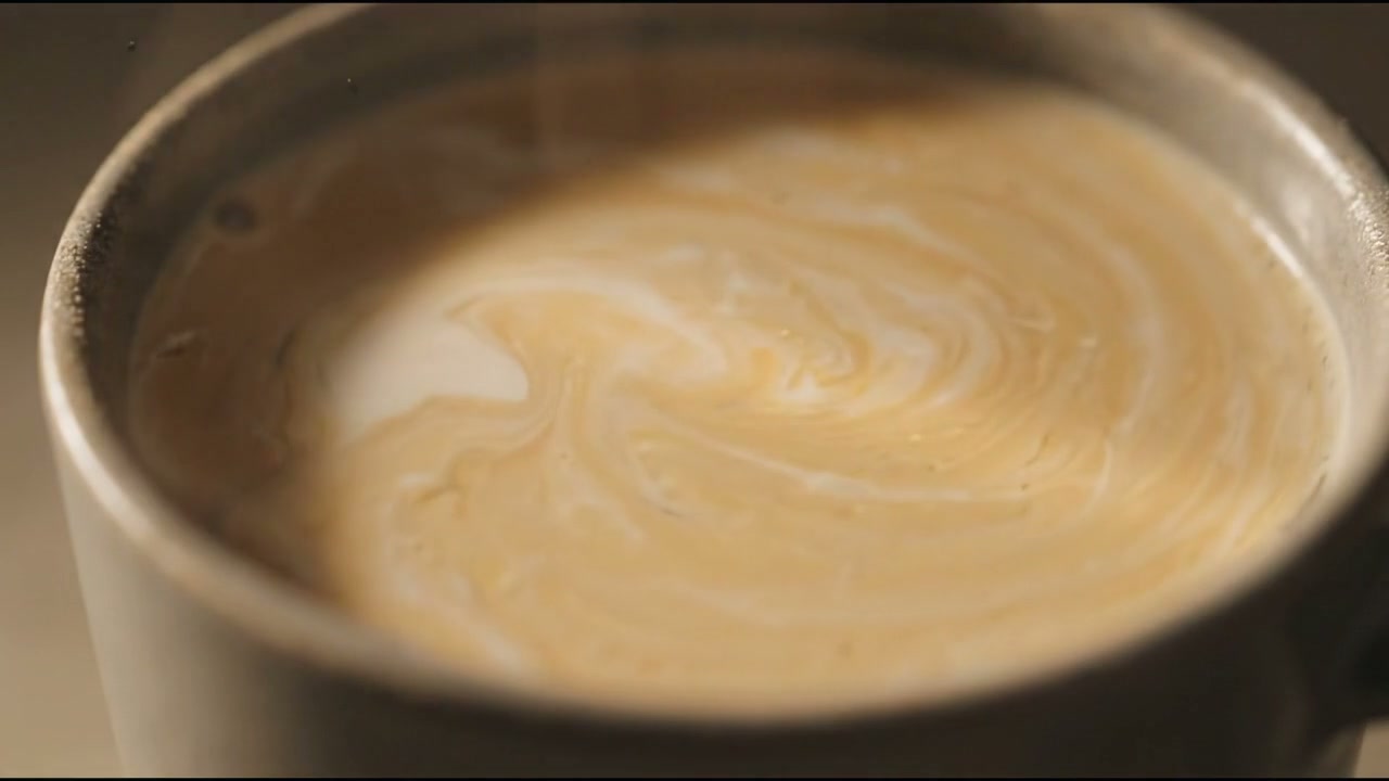 The coffee after stirring, a smooth swirl with the powder fully dissolved